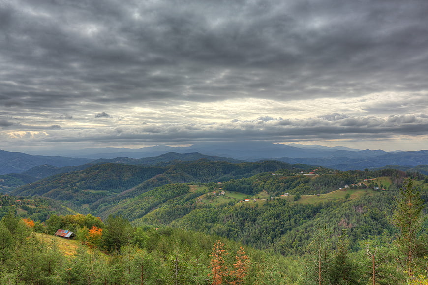 Dramatic cloudy sky over rolling green mountain landscape