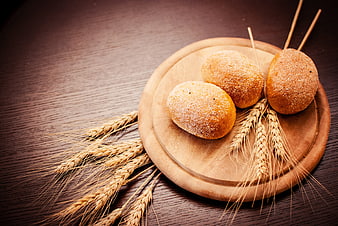 Rustic Bread Rolls on Wooden Board with Wheat Stalks