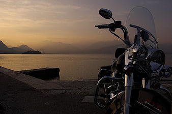 Black Cruiser Motorcycle Parked by Lake at Sunset