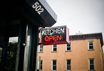 Neon Kitchen Open Sign on Urban Street Corner