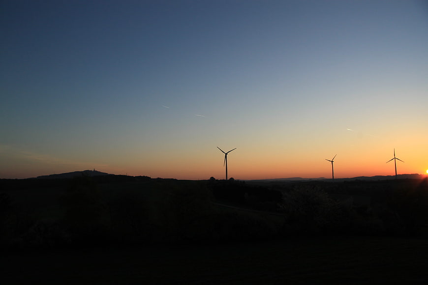 Silhouetted Wind Turbines Against Sunset Sky