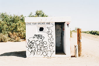 White concrete structure with graffiti in desert landscape