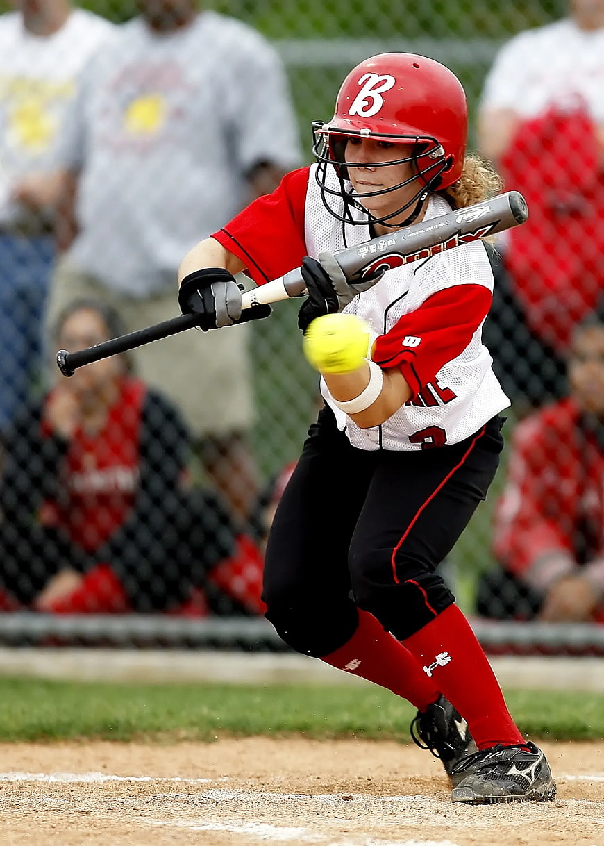 Female Softball Player Swinging Bat at Ball