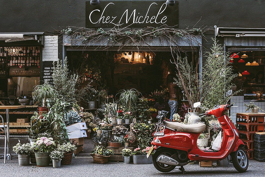 Vintage Red Scooter Parked Outside Flower Shop