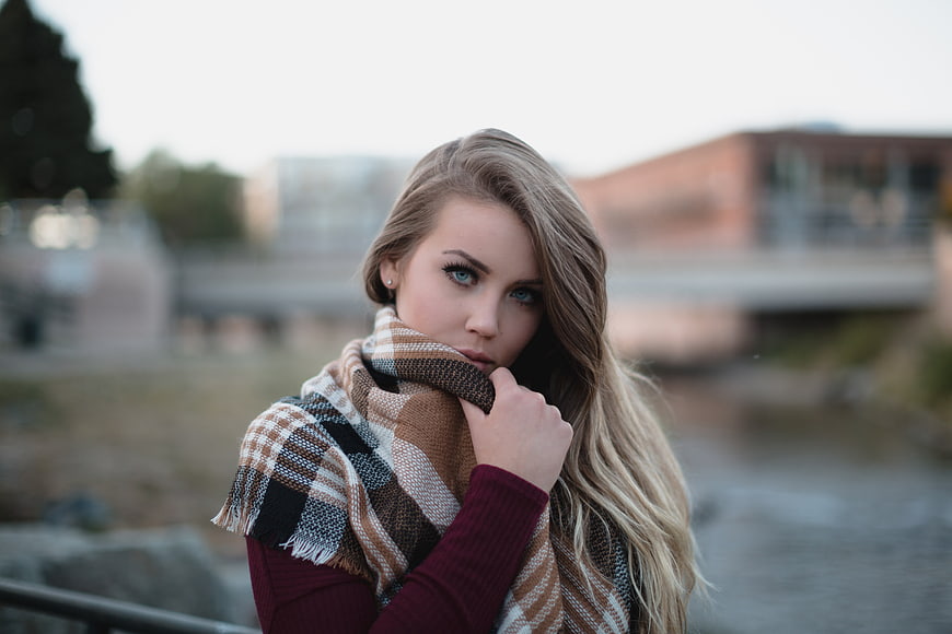Portrait of young blonde woman in plaid scarf outdoors