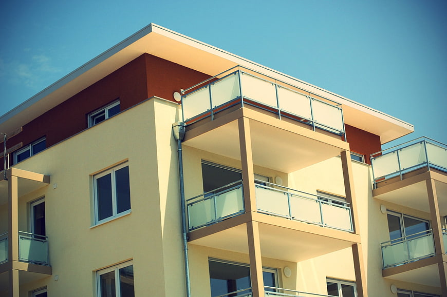 Modern Apartment Building Facade With Balconies And Clear Blue Sky
