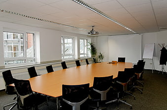 Modern Empty Conference Room With Large Wooden Table And Black Chairs