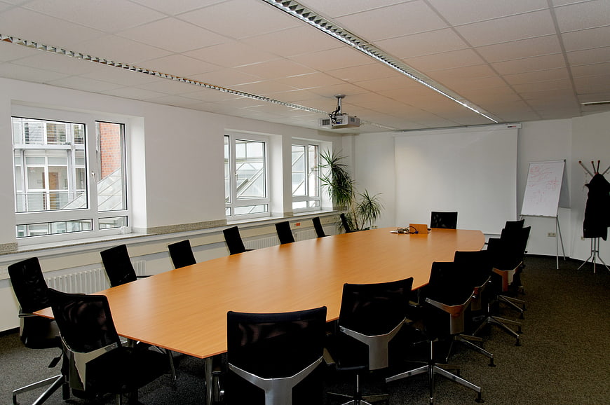 Modern Empty Conference Room With Large Wooden Table And Black Chairs