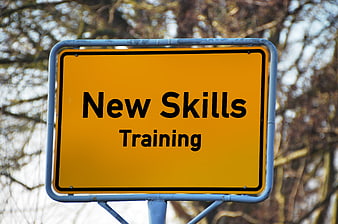 Yellow road sign reading New Skills Training