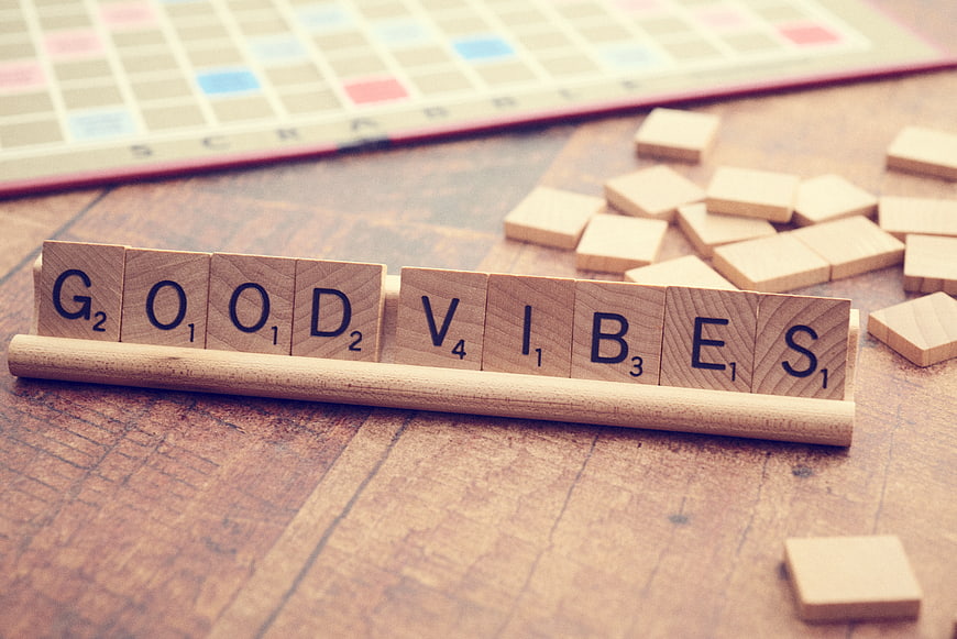 Scrabble Tiles Spelling Good Vibes on Wooden Table