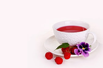 White Cup of Red Tea with Raspberries and Pansy