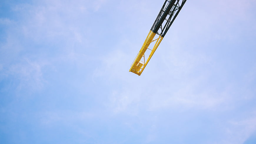 Yellow Construction Crane Arm Against Blue Sky