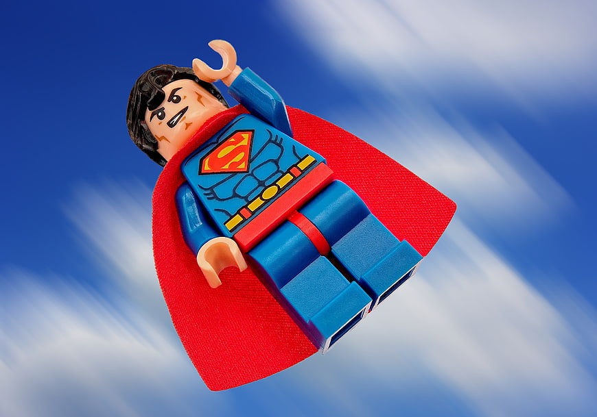 Lego Superman Minifigure Flying Against Blue Sky Background