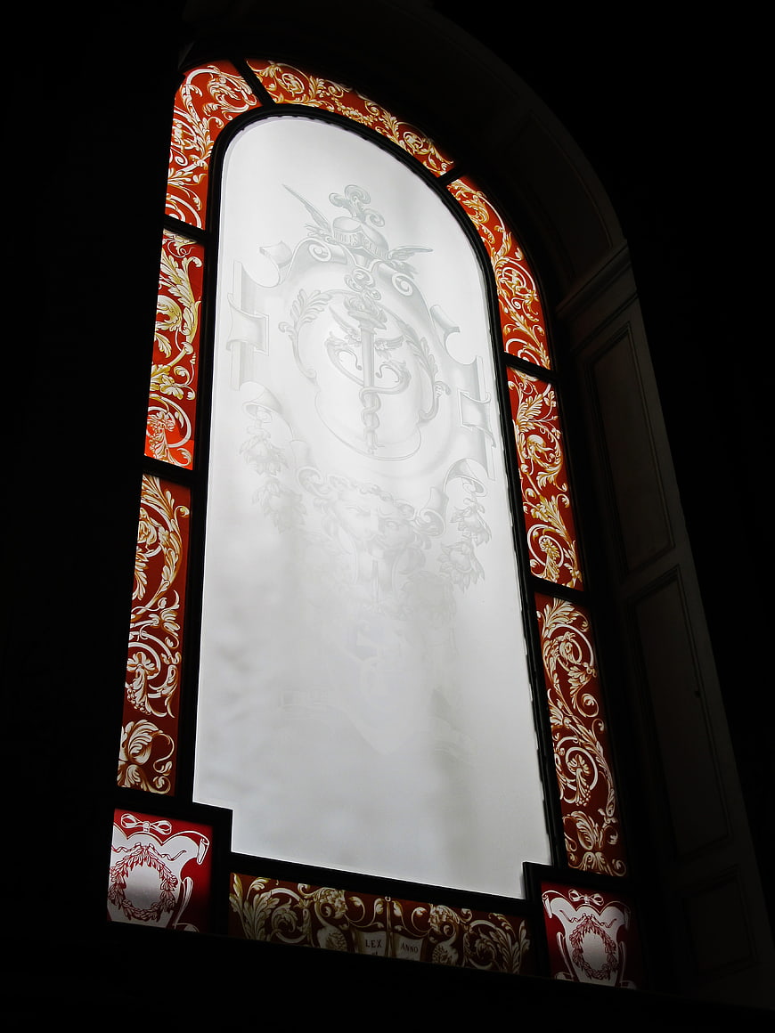 Ornate stained glass window with red and gold patterns