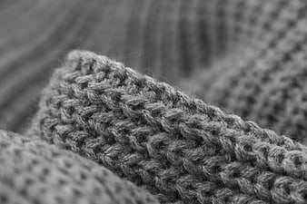 Close-up of gray knitted wool texture in black and white