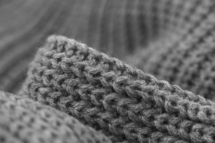 Close-up of gray knitted wool texture in black and white