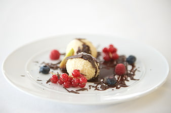 Gourmet ice cream dessert with berries and chocolate sauce