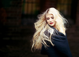 Portrait of blonde woman with red lipstick and dark coat