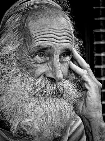 Black and white portrait of elderly bearded man thinking