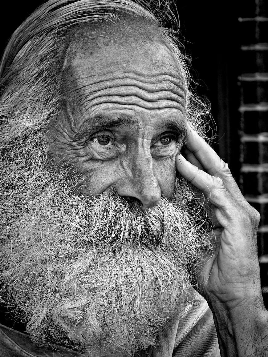 Black and white portrait of elderly bearded man thinking