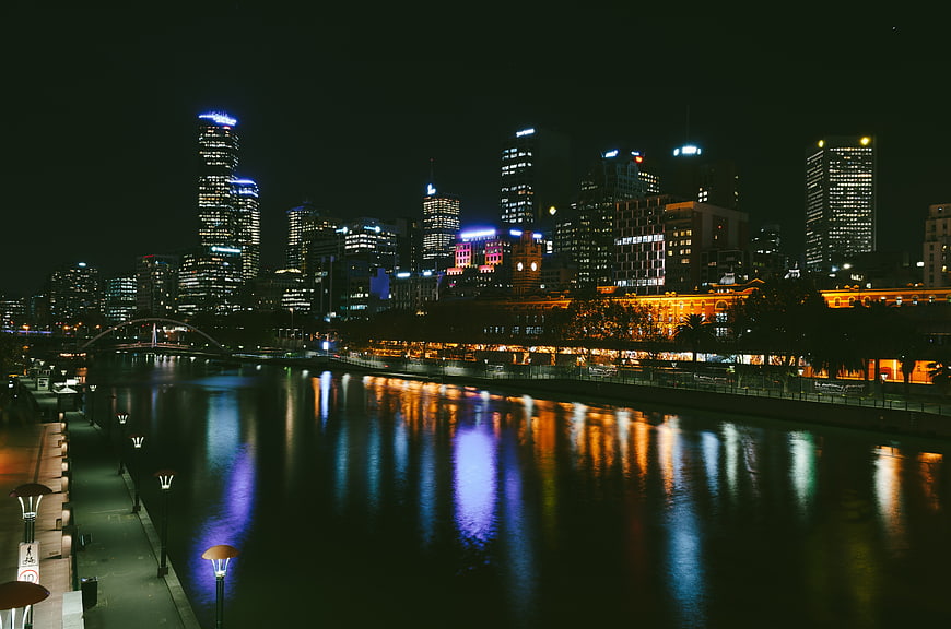 Night cityscape with colorful skyline reflections on river