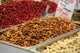 Pile of almonds and hazelnuts in metal market bins