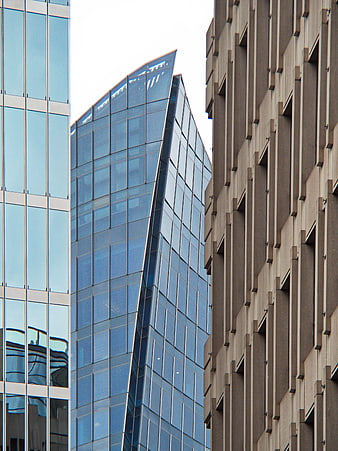 Modern Glass Skyscraper Between Concrete Buildings