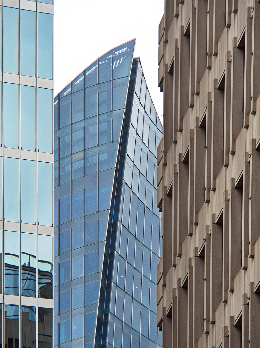 Modern Glass Skyscraper Between Concrete Buildings