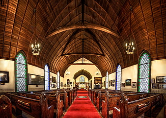 Interior of a historic wooden church with red carpet aisle