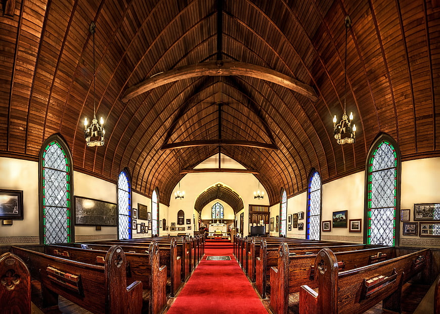 Interior of a historic wooden church with red carpet aisle