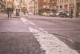 Low angle street view with pedestrian walking away in city