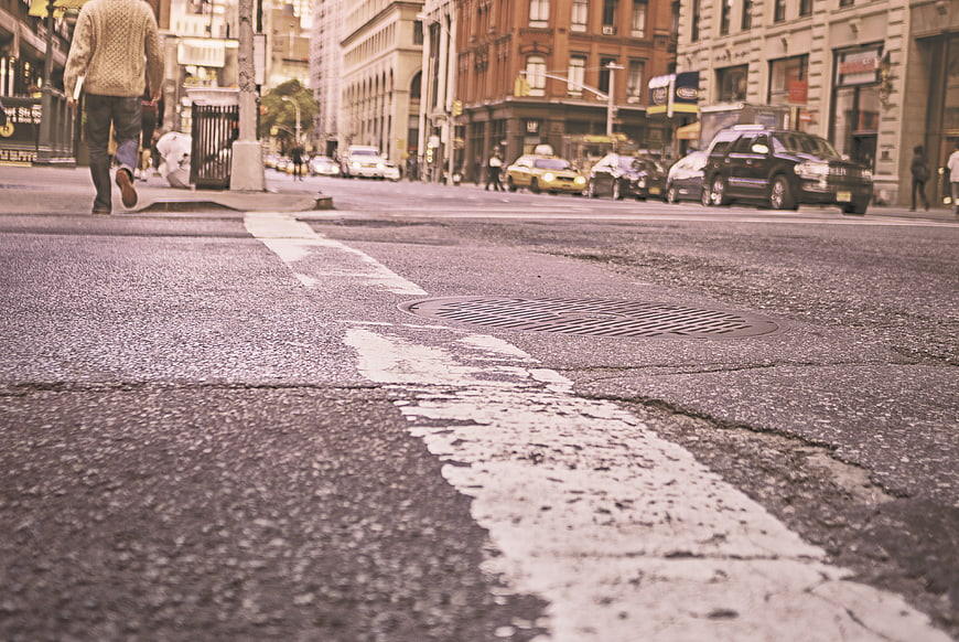 Low angle street view with pedestrian walking away in city