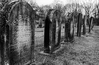 Old weathered tombstones in a historic black and white cemetery
