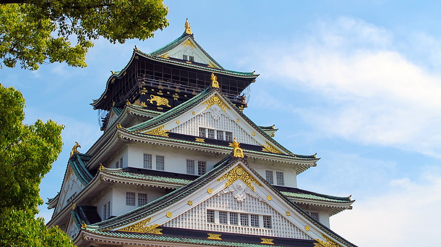 Osaka Castle Tower With Golden Ornaments And Blue Sky