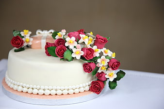 Elegant white cake with pink roses and pearl decoration