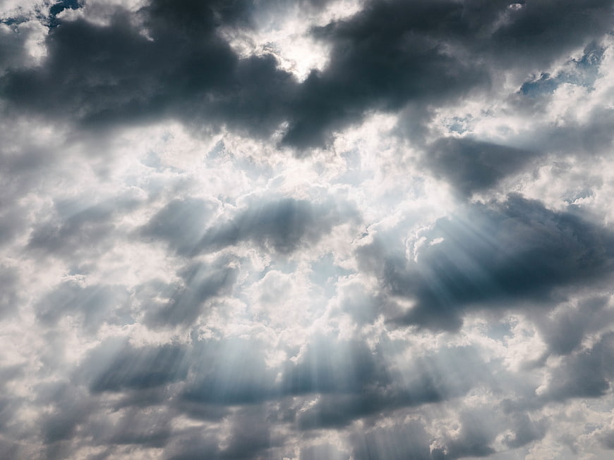 Dramatic Sun Rays Breaking Through Dark Storm Clouds