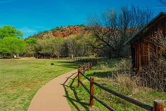 Winding Path Through Park With Red Rock Cliffs