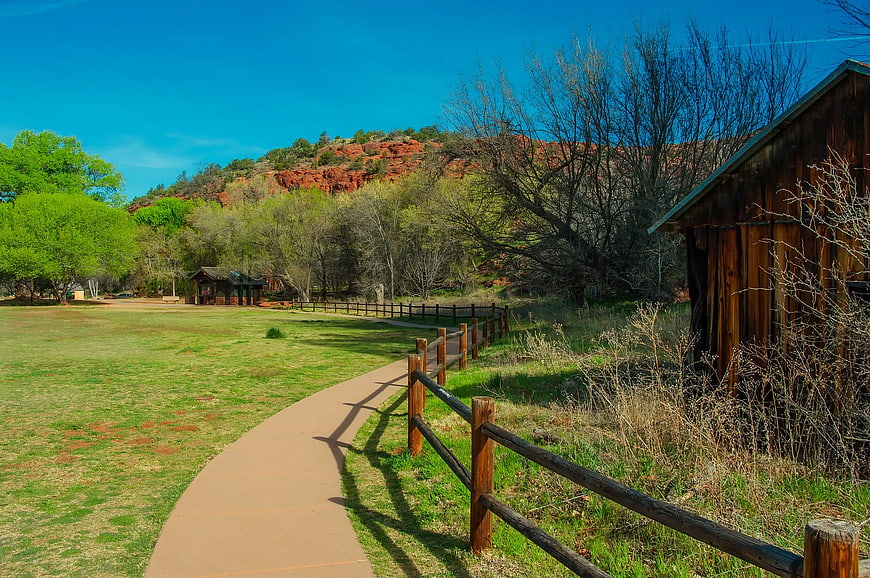Winding Path Through Park With Red Rock Cliffs