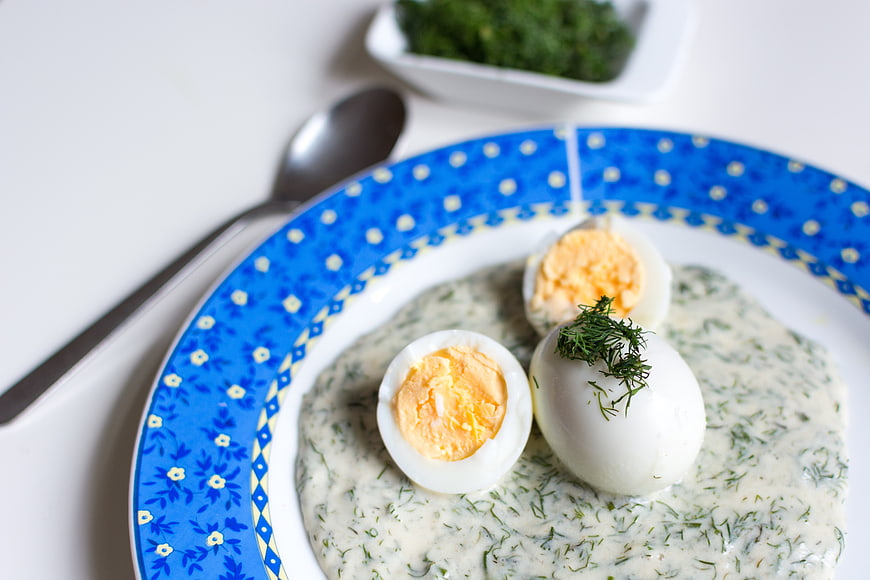Traditional Czech dill sauce with boiled eggs on blue plate