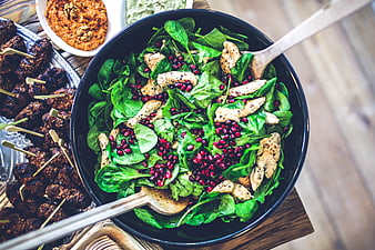 Overhead view of spinach chicken pomegranate salad with falafel