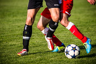 Soccer Players Dueling for the Ball on Grass Field