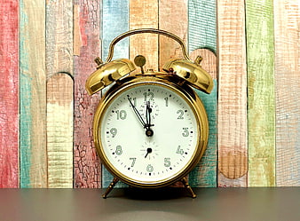 Vintage Gold Alarm Clock on Colorful Wooden Background