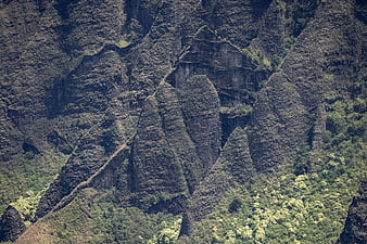 Steep Rocky Mountain Ridge with Lush Green Vegetation