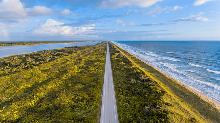 Aerial view of coastal highway between ocean and marshland