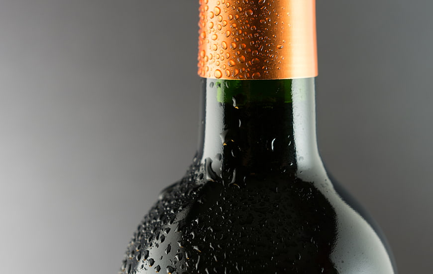 Close-up of chilled wine bottle with condensation droplets