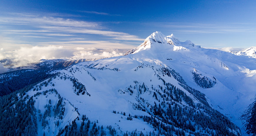 Snow-Capped Mountain Peak with Blue Sky and Clouds