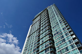 Modern Glass Residential High-Rise Tower Against Blue Sky