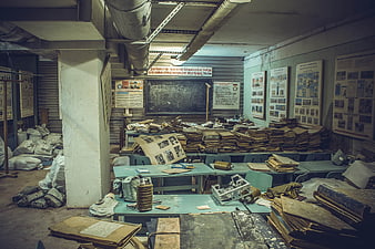 Abandoned Soviet bunker classroom with stacks of documents and military equipment