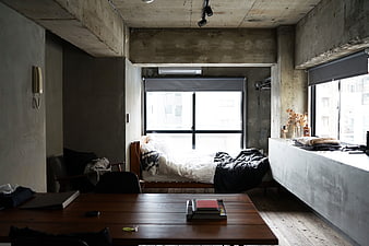 Industrial loft bedroom with concrete walls and wooden furniture