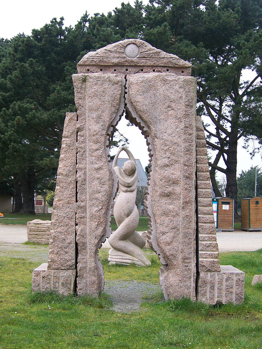 Granite stone sculpture of kneeling figure in park